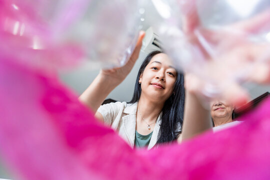 Asian family sorting plastic waste for recycling at home