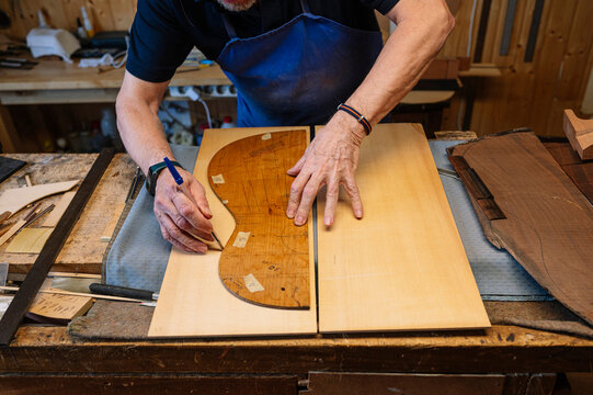 Skilled craftsman tracing guitar in Spanish workshop