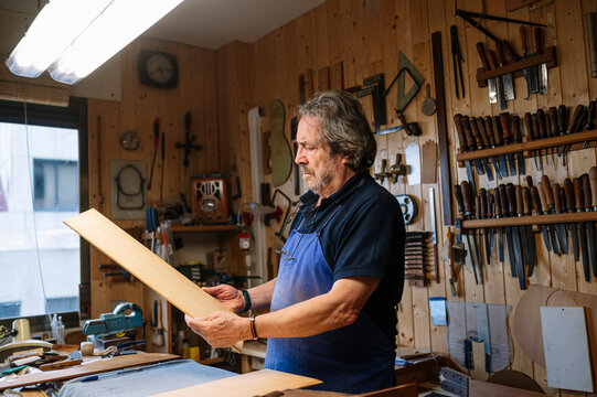 Man crafting guitar in workshop