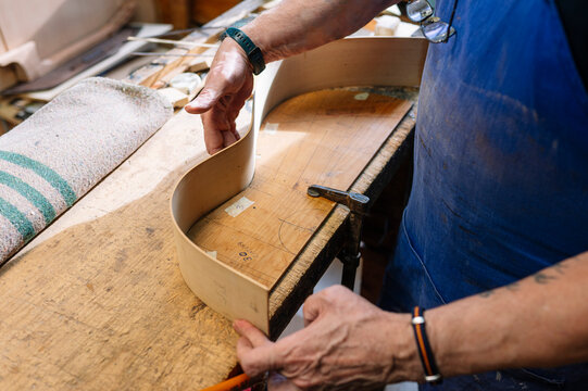 Man crafting guitar in workshop during retirement