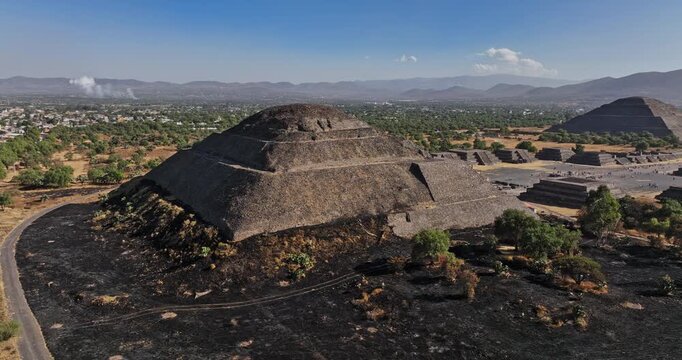 Teotihuacan Mexico Aerial v4 low level fly around pyramid of the moon, capturing avenue of the dead leading to pyramid of the sun and beautiful mountainscape - Shot with Mavic 3 Cine - December 2021