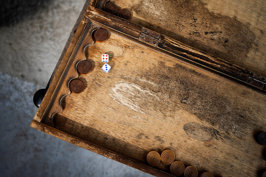 Vintage backgammon board with dice on rustic wood
