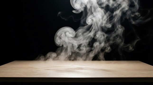 Rising white smoke swirls above a light wooden tabletop against a dark black background creating a dramatic presentation