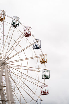 Observation wheel with colorful gondola cabins on sky