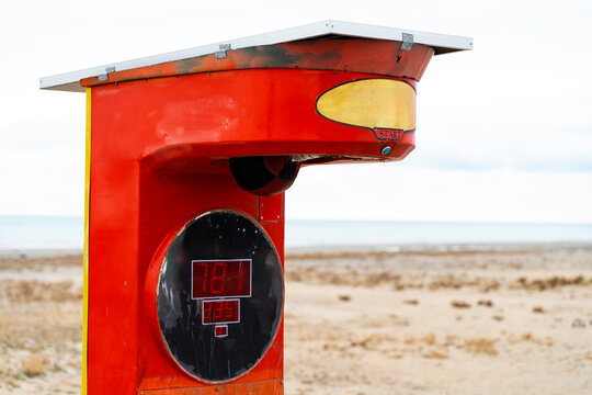 Vintage red arcade punching machine on beach background