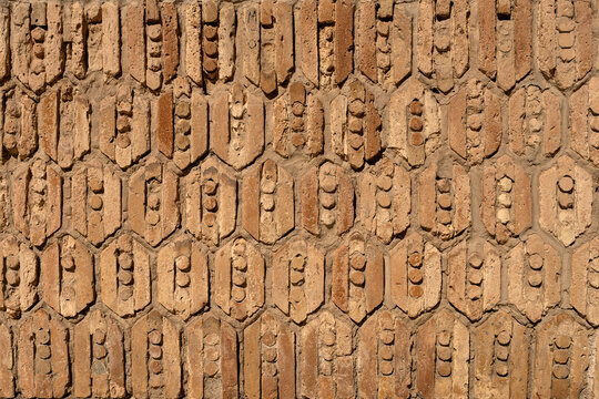 Weathered clay brick wall texture with geometric pattern