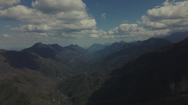 A cinematic aerial drone view overlooking the expansive mountain valleys of El Salto, near Monterrey, Nuevo Le&oacute;n, Mexico. Rolling forested hills, rugged mountain peaks, and dramatic clouds.