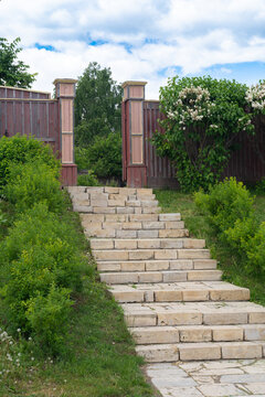 Stone stairway leading to rustic wooden gate in garden