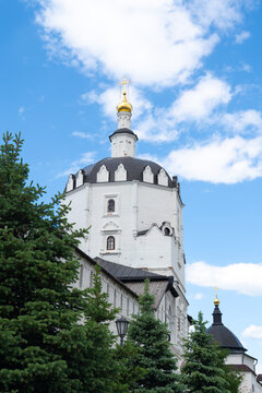 White Orthodox church tower with golden dome and sky