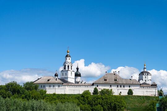 White Orthodox monastery skyline under blue sky with clouds