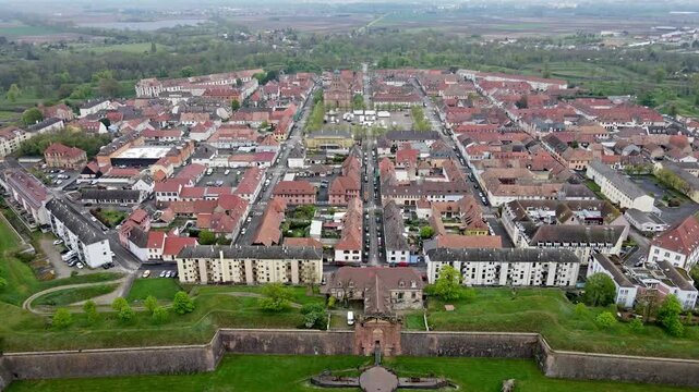 Aerial drone top-down view of fortress rooftop grid showing terracotta tiles and precise street pattern within octagonal walls. Urban block geometry and pavement layout visible from directly above.