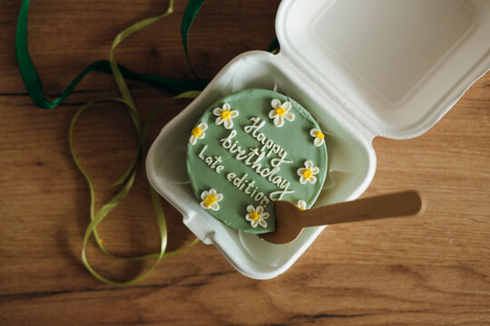 Bento cake with birthday wishes on wooden table