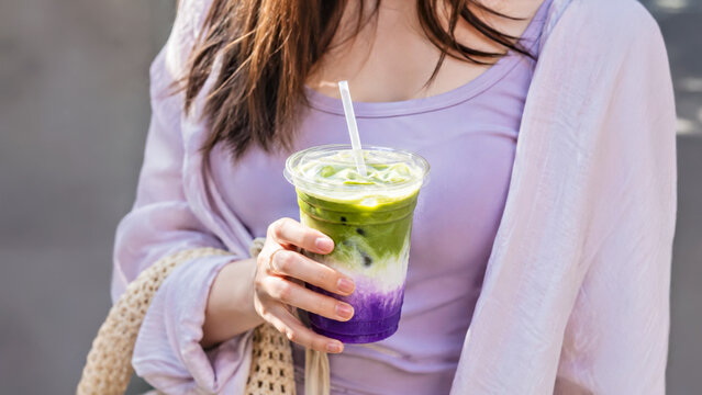 Iced Ube Matcha Latte Held by Young Woman in Natural Daylight
