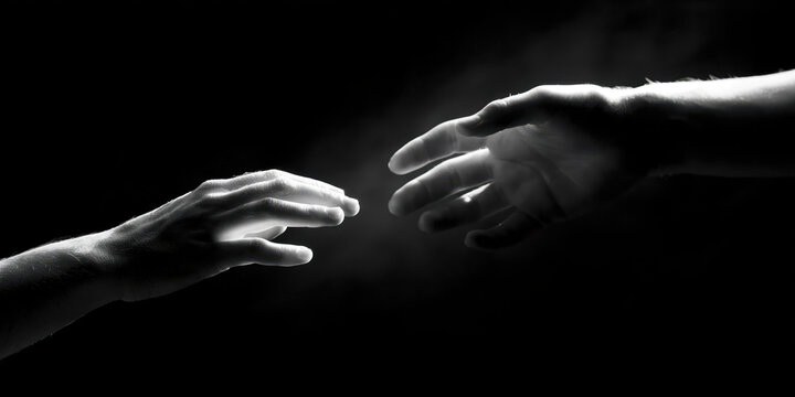 Two hands gently touching in black and white