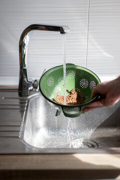 Rinsing Dry Lentils Under Running Water in Kitchen Sink