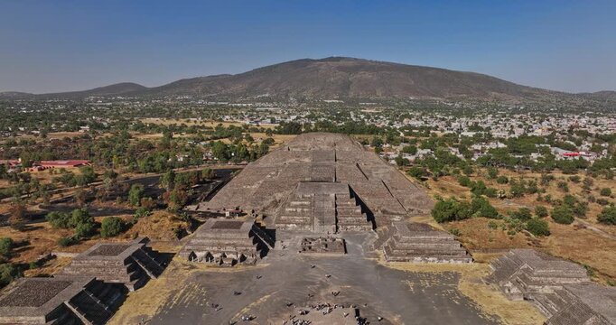 Teotihuacan Mexico Aerial v7 pull out shot away from pyramid of the moon, along the famous avenue of the dead with beautiful mountainscape background - Shot with Mavic 3 Cine - December 2021