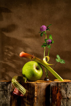 Modern still life with apple, rhubarb, and flowers