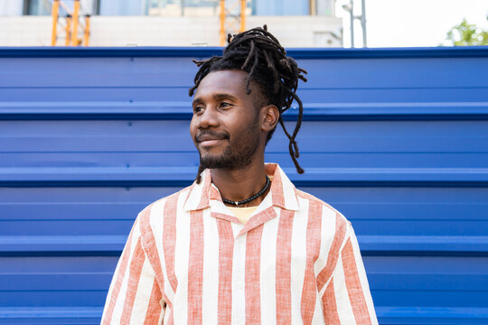 Cuban man with dreadlock hairstyle by blue wall portrait