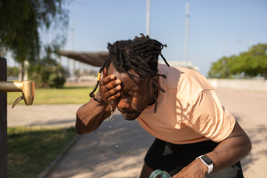 Cuban runner cooling off with water at outdoor fountain