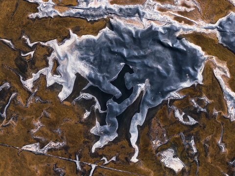 Aerial fine art of magical water patterns in winter marsh
