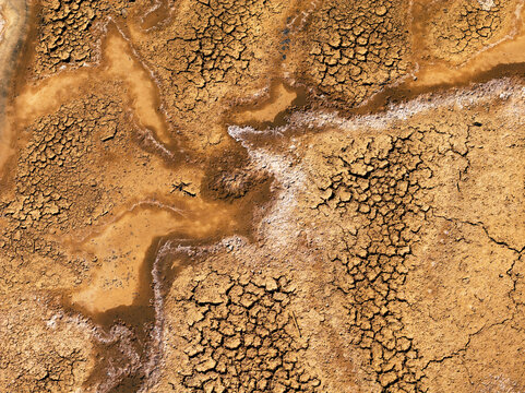 Fine art aerial texture of magical water on cracked earth