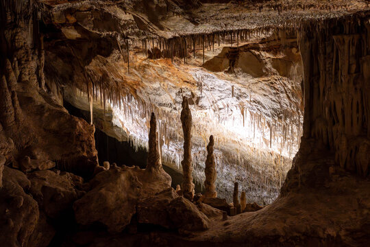 Scenic underground cave with water and stalactites,