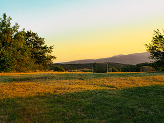 Fototapeta premium Beautiful scenic scene of a mountain meadow with hay bales. Mountain grass fields. Rajac Mountain.