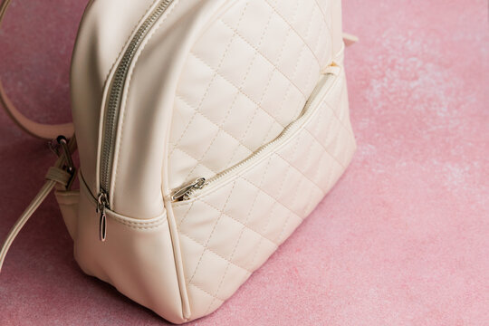 Stylish bag on pink surface showing the design and texture in a simple setting