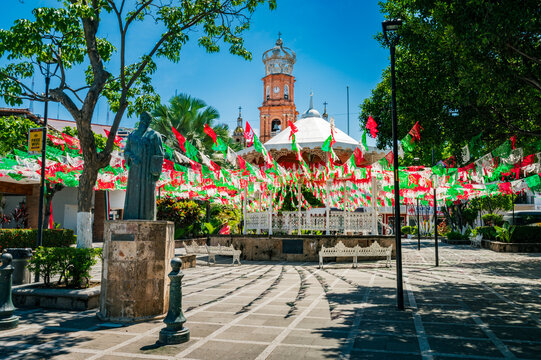 Public plaza with papel picado decorations and Our Lady of Guadalupe Church in Puerto Vallarta, Mexico