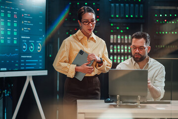 It engineers collaborating on network infrastructure planning in a modern data center server room...