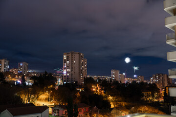 Fototapeta premium Night Rijeka city skyline with fireworks lighting up the sky during New Year’s Eve celebration. Concept of urban festivities, holiday traditions and winter celebrations
