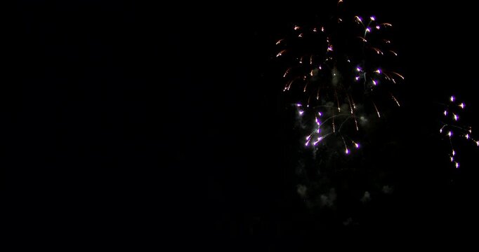 Fireworks Exploding In The Night Sky And Leaving Traces Of Smoke