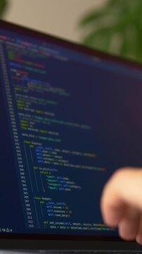 Close-up of hands typing programming code on laptop keyboard while AI assistant supports software development. Vibe coding workflow, coding automation and modern programming process concept.