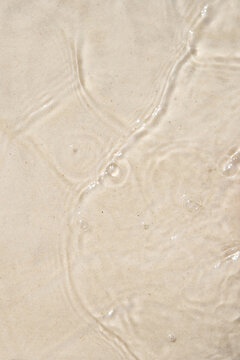 Wet sand with water ripples, abstract beach background and summer coastal texture