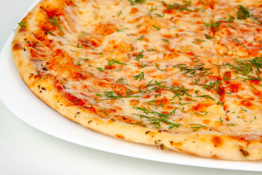 A closeups shot of a baked margherita pizza with melted cheese tomato sauce and fresh chopped herbs. Italian fast food, macro cheesy pastry, savory dinner dish meal. Dining.
