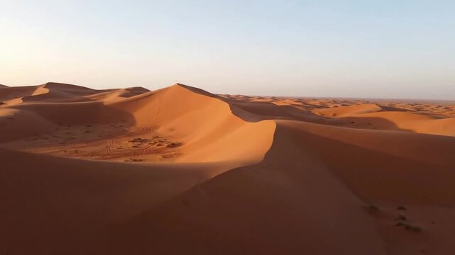 Aerial view of golden sand dunes in sahara desert at sunset, vast arid landscape background