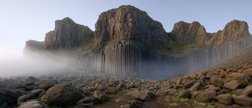 Nature shows rock formations near the sea with mist and clouds in the early morning at a coastal location