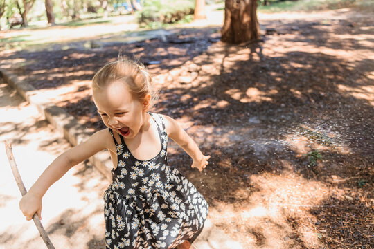Young girl joyfully playing in the sunny park