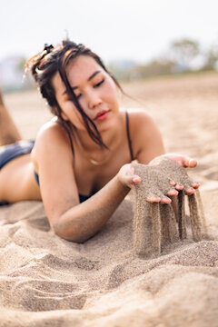 Woman relaxing on sandy beach close to the sea