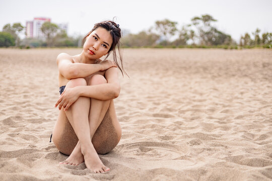 Woman sitting on a sandy beach in peaceful solitude