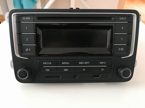 Front view of a Volkswagen car radio with media menu and FM AM control buttons.