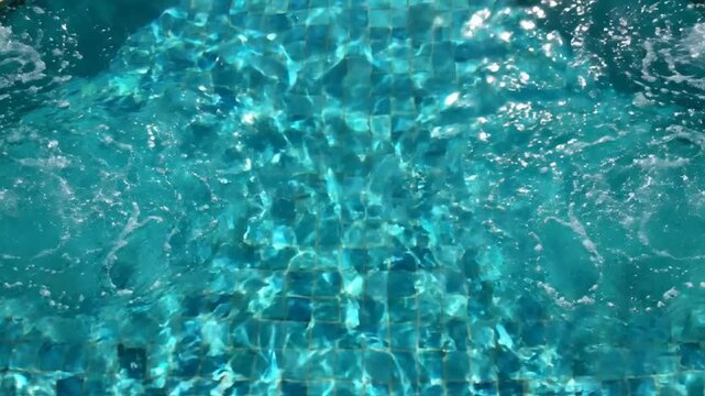 Refreshing swimming pool water with bubbling jet stream and blue mosaic tiles, relaxing summer vacation background, for wellness and, spa concepts
