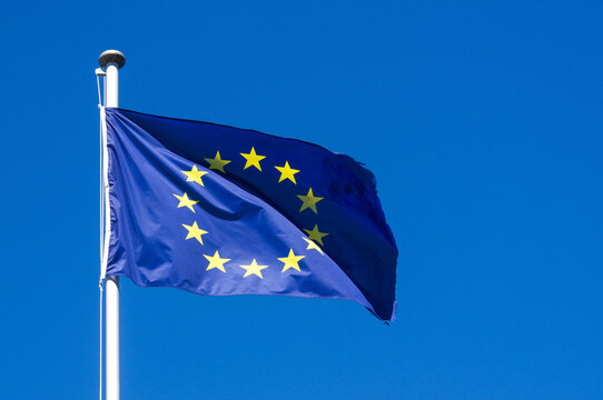 European Union flag waving against a clear blue sky in Campione d'Italia