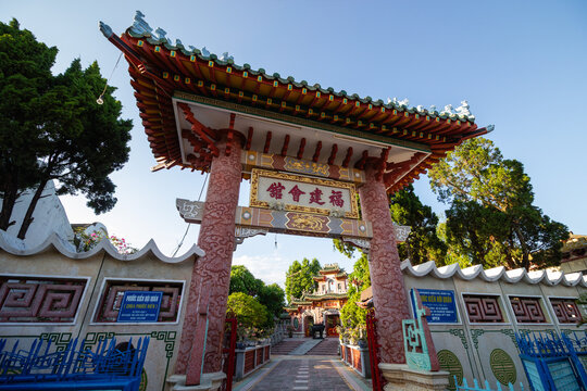 The ornate entrance gate of the historic Fujian Assembly Hall Hoi Quan Phuoc Kien under a blue sky in Hoi An Vietnam