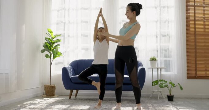 Portrait of young asian mother  daughter prepare for stretching post in yoga meditation. Mom and little girl toddler yoga exercise on yoga mat at home. Together lifestyle, Mother's Day concept