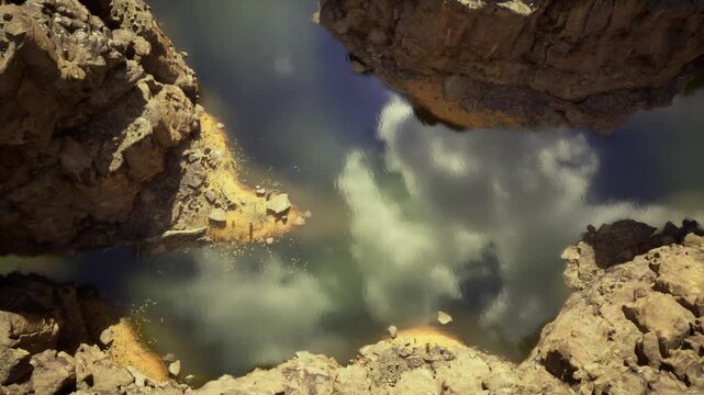 Closeup rocky inlet at vermilion cliffs, algae patches, subtle water ripple, rugged sandstone ledges, lowangle light, quiet secluded mood, geological pattern