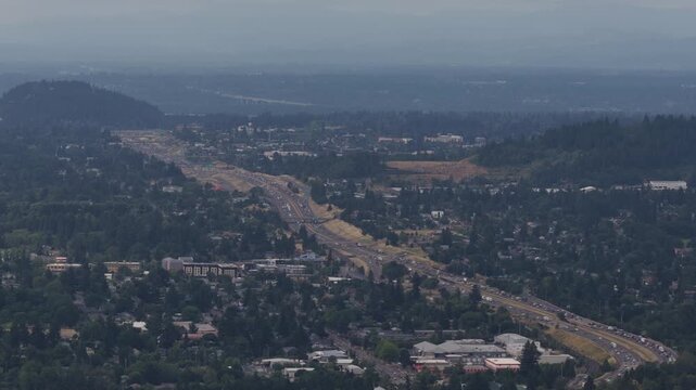 Aerial of suburban forested corridor on highway 205 in southeast Portland Oregon with a major transportation corridor featuring multilane highway and commercial development in summer