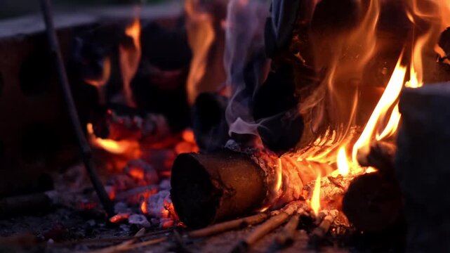 Burning wood boards in the oven close up. Burning firewood and smoke in the handmade oven. Flame in a cozy fireplace at outdoor, keep warm. Hot background.