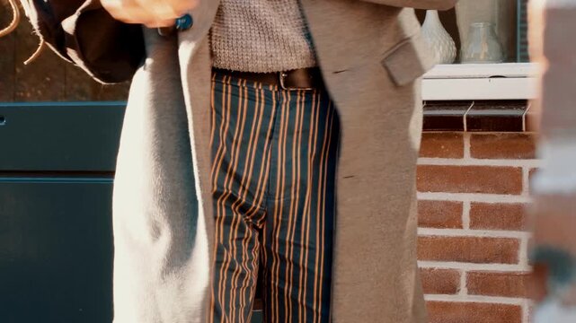 Boy searches the pockets of his pants for the keys to his house.
