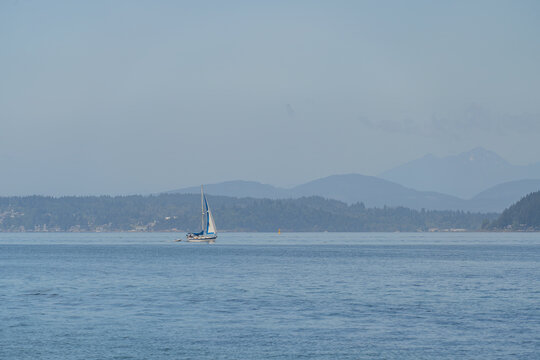 Sailboat on calm water with mountains in background